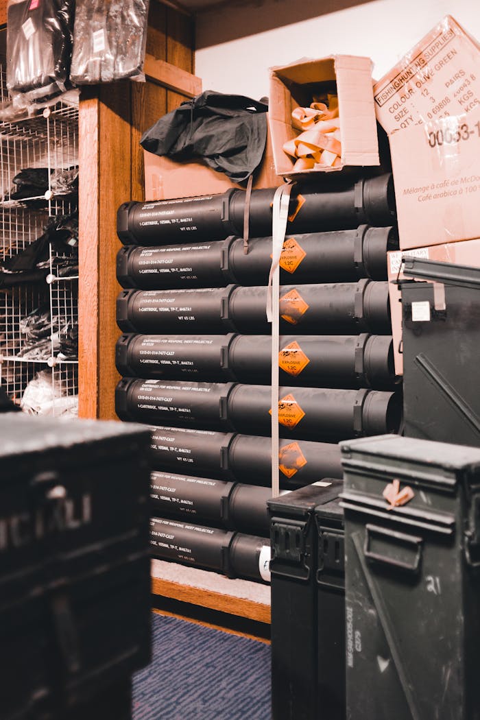 Stacked black storage cases and containers in a well-organized industrial warehouse setting.